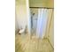 Bathroom including a toilet, tiled floors, and a shower with white walls and a white curtain at 106 Pyracantha Ln, Leesburg, FL 34748
