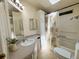 Bright bathroom features a sink, large mirror, and shower with decorative curtain, illuminated by a skylight at 106 Pyracantha Ln, Leesburg, FL 34748