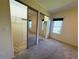 Bright bedroom featuring carpeted floors, closet with mirror doors and natural light from the windows at 106 Pyracantha Ln, Leesburg, FL 34748