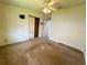 Simple bedroom featuring standard closet, ceiling fan with an attached light, and tan carpet at 106 Pyracantha Ln, Leesburg, FL 34748