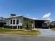 Charming single-story home with a carport, manicured lawn, and mature landscaping under a sunny sky at 106 Pyracantha Ln, Leesburg, FL 34748