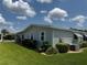 Exterior view features well manicured green lawn and trimmed shrubs, adjacent to the manufactured home at 106 Pyracantha Ln, Leesburg, FL 34748