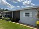 Exterior view of the home featuring well-maintained landscaping, light gray paint and trimmed lawn at 106 Pyracantha Ln, Leesburg, FL 34748