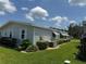 The house exterior features healthy landscaping and grass, trimmed bushes, and painted gray siding at 106 Pyracantha Ln, Leesburg, FL 34748