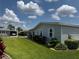 Home exterior with green lawn, trimmed bushes, street lamp, and neighboring manufactured home at 106 Pyracantha Ln, Leesburg, FL 34748