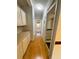 Bright hallway features wood-look flooring and ample cabinet space with an open doorway to a closet with storage at 106 Pyracantha Ln, Leesburg, FL 34748