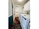 Laundry room featuring modern machines, decorative wallpaper, and outdoor access at 106 Pyracantha Ln, Leesburg, FL 34748