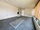 Enclosed patio space boasting gray tiled flooring, vinyl walls and ceiling, and ample natural light at 106 Pyracantha Ln, Leesburg, FL 34748