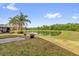 Expansive backyard overlooking a serene pond with lush greenery and mature palm trees at 11172 Pinewood Cove Ln, Orlando, FL 32817