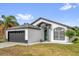 Single-story home with gray roof, two-car garage, and a manicured lawn at 11172 Pinewood Cove Ln, Orlando, FL 32817