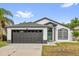 Charming single-story home features a gray roof, a two-car garage, and a well-maintained front yard at 11172 Pinewood Cove Ln, Orlando, FL 32817