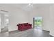 View of living room with gray floors, sliding glass doors and access to other rooms at 11172 Pinewood Cove Ln, Orlando, FL 32817