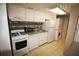 Bright kitchen featuring white appliances and cabinets, with tile backsplash at 125 Water Front Way # 200, Altamonte Springs, FL 32701