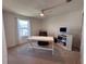 Bright bedroom featuring a ceiling fan, a modern computer setup, and a comfortable brown chair at 1258 Wispy Cypress Drive Dr, Kissimmee, FL 34746