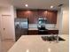 Kitchen featuring stainless steel appliances, granite countertops and dark wood cabinets at 1258 Wispy Cypress Drive Dr, Kissimmee, FL 34746