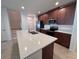 Kitchen with a large island, stainless steel appliances and dark wood cabinets at 1258 Wispy Cypress Drive Dr, Kissimmee, FL 34746