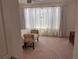 This bedroom features carpet and large windows covered by translucent white curtains at 1258 Wispy Cypress Drive Dr, Kissimmee, FL 34746