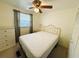 Comfortable bedroom featuring neutral carpet, a large window, and a ceiling fan at 129 Dogwood Trl, Leesburg, FL 34748