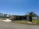 Comfortable home with carport, a tidy yard and a shade-providing palm tree at 129 Dogwood Trl, Leesburg, FL 34748