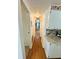 Hallway leading to a bedroom and kitchen featuring wood floors and neutral walls at 129 Dogwood Trl, Leesburg, FL 34748