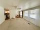 Open living room showing seamless flow to the kitchen and dining area with neutral carpet at 129 Dogwood Trl, Leesburg, FL 34748