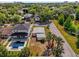 Aerial view showcasing a home with a pool, palm trees, and lush greenery in a residential area at 1600 Hart Ln, Orlando, FL 32804