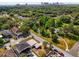 Aerial view of a neighborhood with mature trees, a pond, and a glimpse of the city skyline at 1600 Hart Ln, Orlando, FL 32804