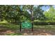 Entrance sign to Guernsey Park featuring lush greenery with a bridge and mature trees at 1600 Hart Ln, Orlando, FL 32804