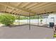 Covered patio featuring a concrete slab, providing an outdoor space with a white fence and green foliage at 1600 Hart Ln, Orlando, FL 32804