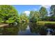 Picturesque pond reflecting lush green trees under a blue sky, creating a serene and natural landscape at 1600 Hart Ln, Orlando, FL 32804