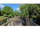 Scenic pond view from a wooden bridge featuring lush greenery and a clear blue sky at 1600 Hart Ln, Orlando, FL 32804