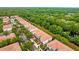 Aerial view of a tree-lined street featuring townhomes with red tile roofs in a verdant neighborhood at 1880 Garden Sage Dr, Oviedo, FL 32765