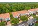Aerial view of townhomes showcasing blue exteriors, red tile roofs, and meticulously landscaped grounds at 1880 Garden Sage Dr, Oviedo, FL 32765