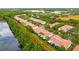 Aerial view of residential townhomes with red tile roofs, near a pond and retail stores at 1880 Garden Sage Dr, Oviedo, FL 32765