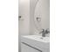 Bathroom featuring a white vanity with modern faucet and a round mirror at 1880 Garden Sage Dr, Oviedo, FL 32765