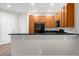 Well-lit kitchen with wood cabinets, granite countertop and bar top seating at 1880 Garden Sage Dr, Oviedo, FL 32765