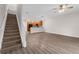 Spacious living area featuring sleek vinyl floors, a staircase, and a view of the modern kitchen at 1880 Garden Sage Dr, Oviedo, FL 32765