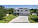 Expansive shot of the two-story home with solar panels on a spacious lot and long driveway at 1940 Bell Creek Loop, Fruitland Park, FL 34731