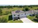 Aerial view of a two-story home featuring solar panels, situated on a large lot with lush greenery at 1940 Bell Creek Loop, Fruitland Park, FL 34731
