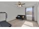 Bright bedroom features a futon, ceiling fan, and a window with natural light at 1940 Bell Creek Loop, Fruitland Park, FL 34731