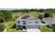 Two-story home with a three-car garage, manicured lawn, and solar panels at 1940 Bell Creek Loop, Fruitland Park, FL 34731