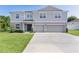 Charming two-story home with a well-manicured lawn, a double garage and complementary landscaping at 1940 Bell Creek Loop, Fruitland Park, FL 34731