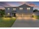 Charming two-story home at dusk with a well-manicured lawn, a double garage and complementary landscaping at 1940 Bell Creek Loop, Fruitland Park, FL 34731