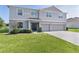 Charming two-story home featuring a well-maintained lawn and a welcoming entrance with manicured bushes at 1940 Bell Creek Loop, Fruitland Park, FL 34731