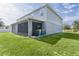 Back of house features a screened in patio and a large green backyard at 1940 Bell Creek Loop, Fruitland Park, FL 34731