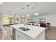 Open concept kitchen showcasing a large island with barstool seating and modern appliances at 1940 Bell Creek Loop, Fruitland Park, FL 34731