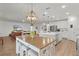 Bright, open kitchen featuring a large island, white cabinetry, and modern stainless steel appliances at 1940 Bell Creek Loop, Fruitland Park, FL 34731