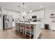 Modern kitchen features a large island with bar seating, stainless steel appliances, and pendant lighting at 1940 Bell Creek Loop, Fruitland Park, FL 34731