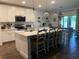 Bright kitchen with white cabinets, a large island with seating, and modern pendant lighting at 1940 Bell Creek Loop, Fruitland Park, FL 34731
