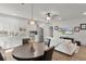 Bright open-concept living room with a dining area, white sofa, and modern ceiling fan at 1940 Bell Creek Loop, Fruitland Park, FL 34731